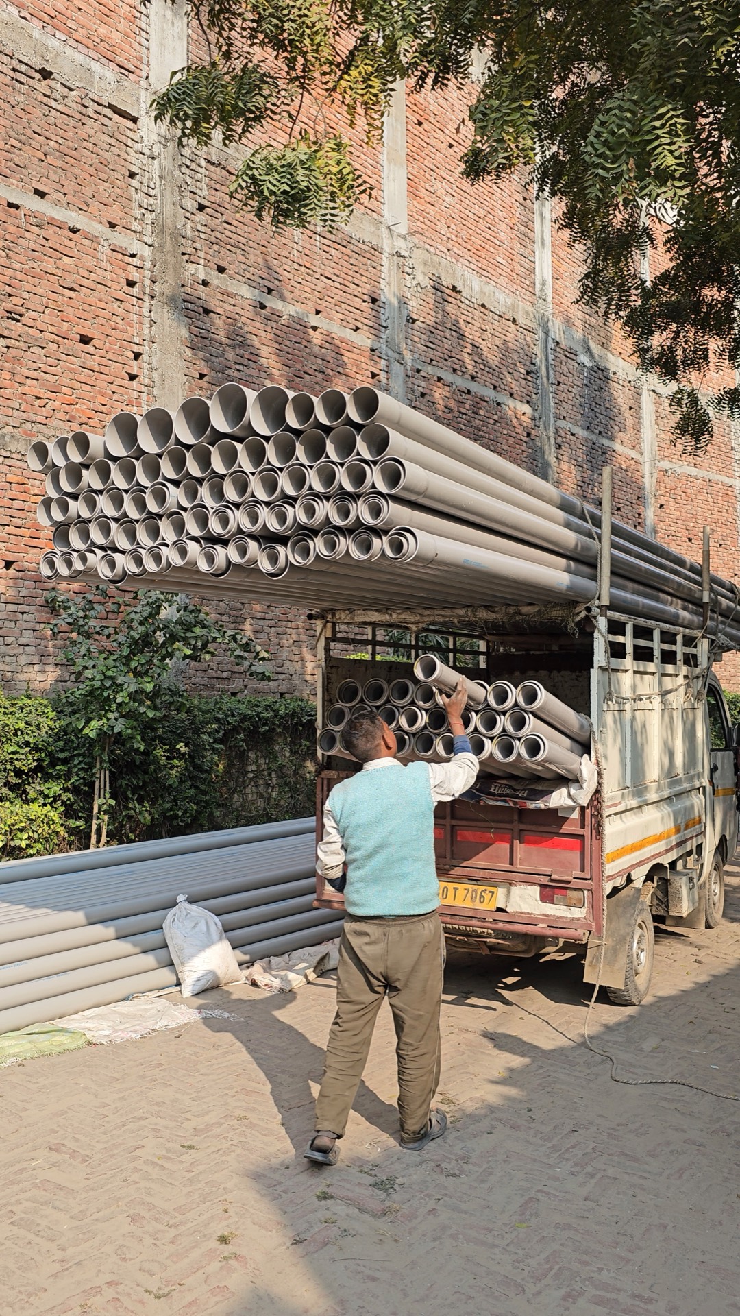 Perfit team loading pipes for delivery